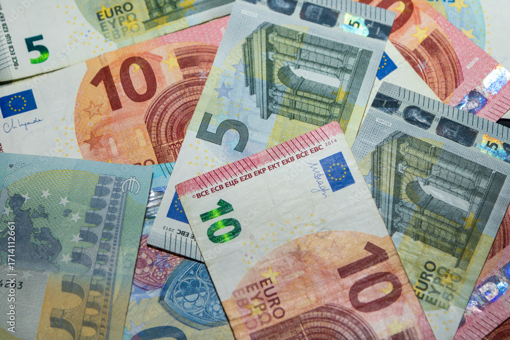 Obraz premium Close up of euro banknotes background. Pile of euro paper money in different denominations. European currency texture for finance, banking, economy, inflation