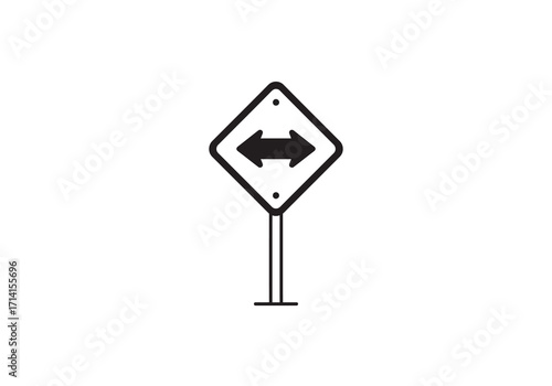 A blackandwhite road sign with arrows pointing left and right is mounted on a post
