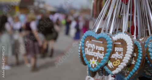 Close up Oktoberfest cookie heart with blurred background shows traditional German celebration. Oktoberfest cookie detail includes white icing text greetings from Oktoberfest
