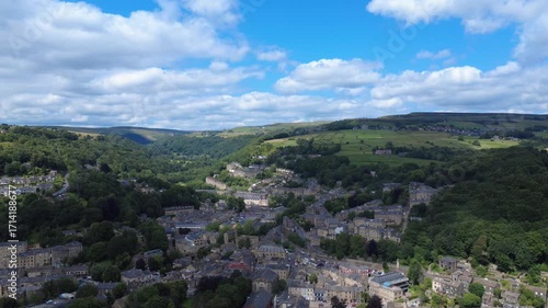 scenic aerial view of the town of hebden bridge in summer sunshine surrounded by fields and hills