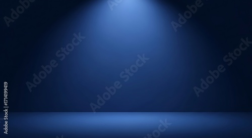 Dark blue studio background with a single spotlight illuminating the floor image photo