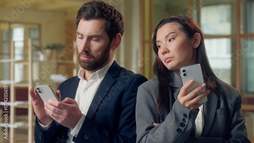 Foto Multiethnic team Korean businesswoman glance at Caucasian businessman mobile pho