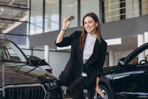 Happy young woman buying new car holding key