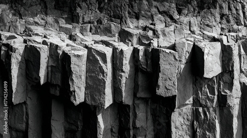 A monochrome image of basalt columns showing the geological rock formation in a close up view