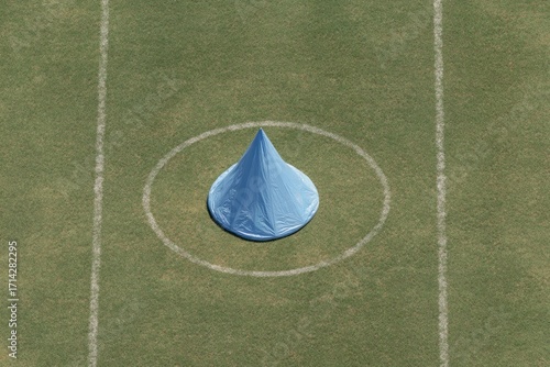 Blue tent-shaped marker in center circle of a grassy field