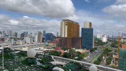 Panoramic view of Phnom Penh city skyline in Cambodia. Mix of modern skyscrapers, hotels, and urban architecture under dramatic clouds, showcasing the rapid development and vibrant atmosphere