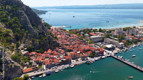 Omis Croatia aerial old town beside turquoise Velika Plaza beach marina and Biokovo mountains under clear summer sky