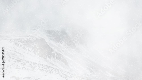 Snow Covered Mountain Peaks in Heavy Winter Storm, Misty Snowy Mountains with Dense Winter Clouds
