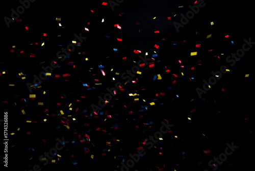 Colorful and multiform glitter confetti explosion on a black background, studio shot. Moment of happiness and festivity concept.