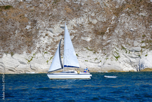 Photos Sailing on a modern monohull sailing yacht on the south coast of england, with sails gently blowing in the wind and the dorset landscape