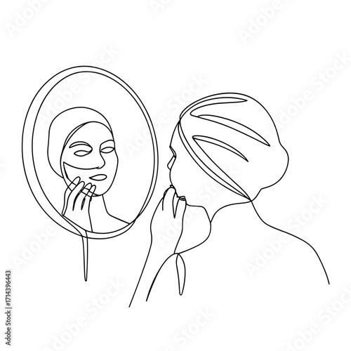 Woman applying face mask while looking in round mirror  