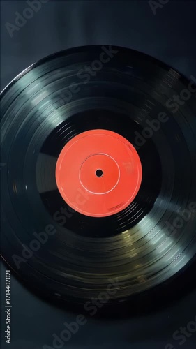 A vinyl record with a red label in a turntable.