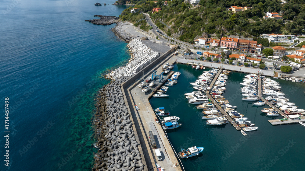 Fototapeta premium Aerial view of boats anchored in the port of Maratea, in the province of Potenza, Basilicata, Italy. It is a small marina overlooking the blue waters of the Mediterranean Sea.