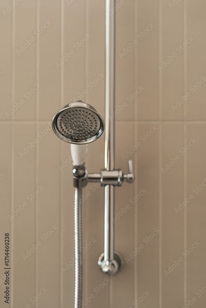 Fototapeta premium Modern shower head in elegant hotel bathroom with chic tiled walls