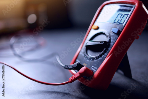red digital multi meter placed on black table is the measuring instrument for electric equipment