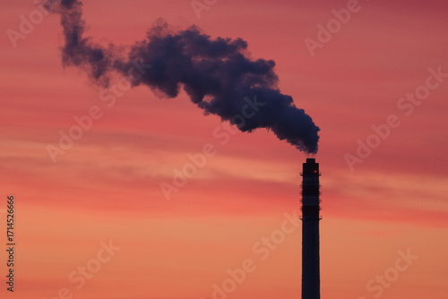 Schilderij op canvas a smoking chimney against the background of sunrise
