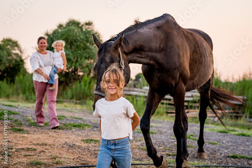 close up portrait of young girl on a horse while horseback riding at sunset in the countryside smiling