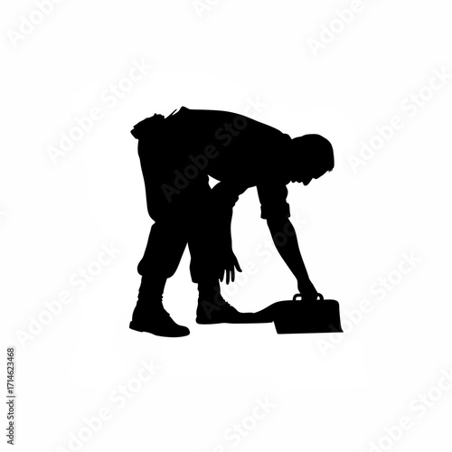 Silhouette of a worker bending down applying finishing touches isolated on white background