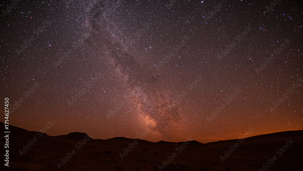 Naklejka premium Vast Milky Way Galaxy Spanning Over Desert Skies