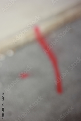 A dreamy vague view of a red line on a concrete sidewalk.