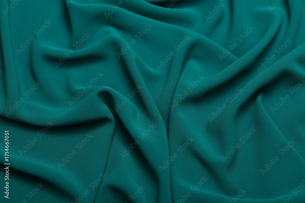Fototapeta premium Soft lightweight flowy georgette fabric in teal green, elegantly draped with natural folds. Perfect for fashion design, textiles, sewing, dressmaking, and delicate feminine style concepts.