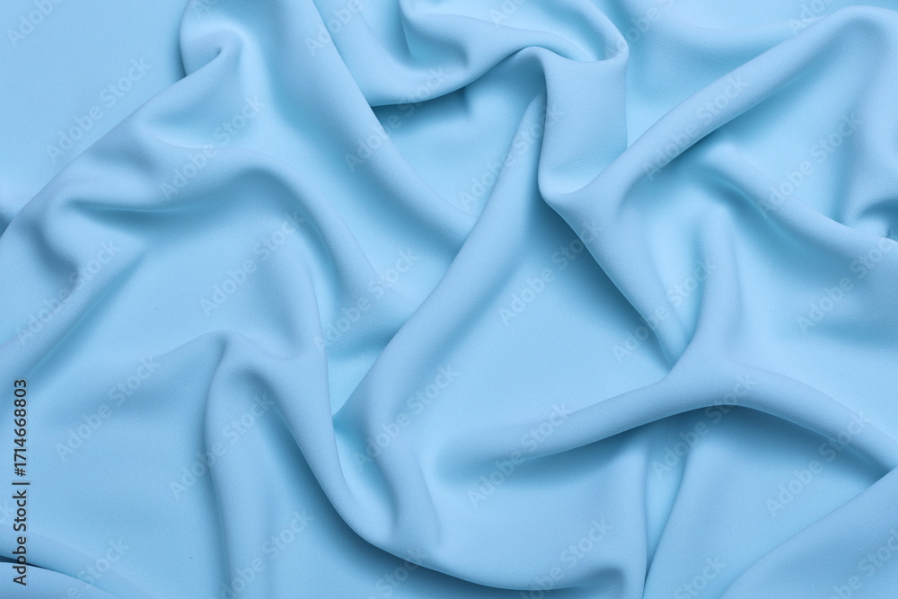 Fototapeta premium Soft lightweight flowy georgette fabric in pastel light blue, elegantly draped with natural folds. Perfect for fashion design, textiles, sewing, dressmaking, and delicate feminine style concepts.