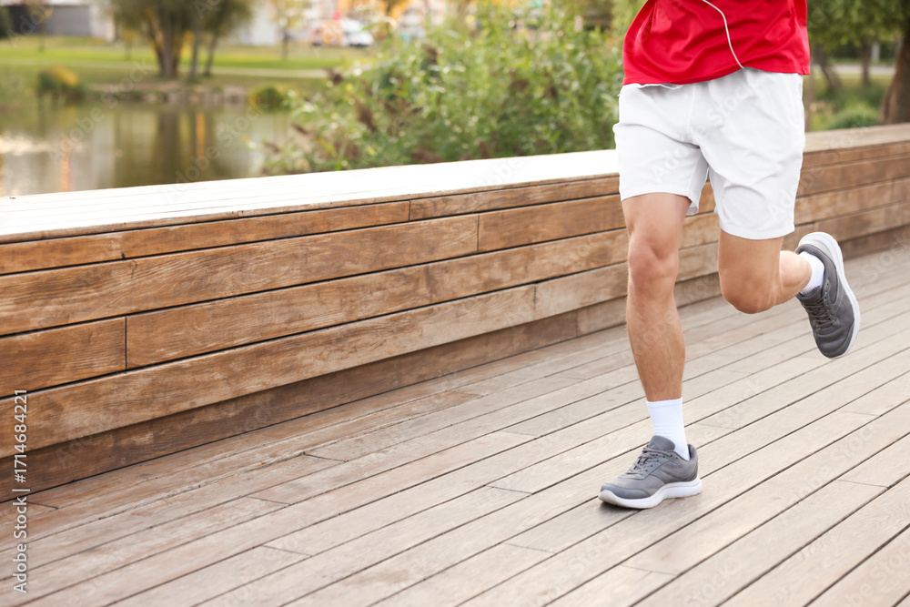 Obraz premium Athletic man in sportswear running outdoors, closeup
