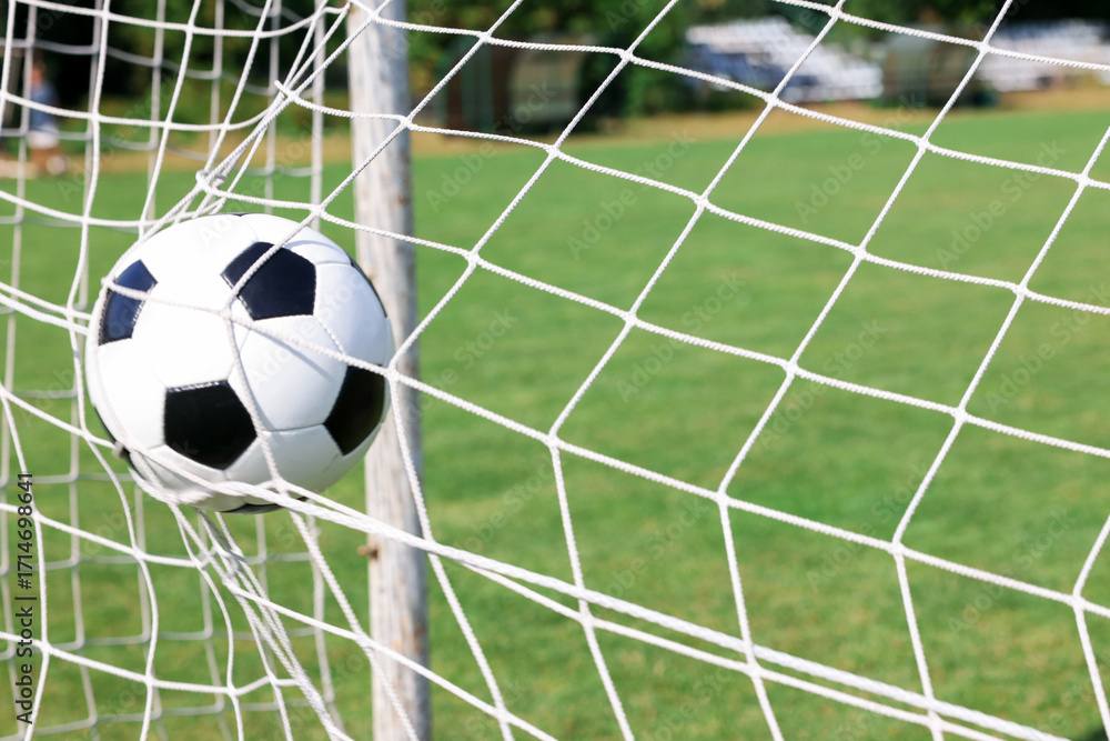 Naklejka premium Hitting soccer ball in net outdoors, closeup. Football game