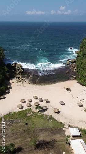 Aerial View of Tropical Beach with Cottages and Vibrant Blue Ocean