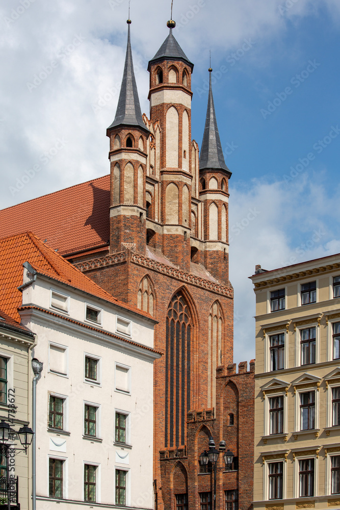 Fototapeta premium Red brick Gothic Church of the Blessed Virgin Mary with three distinctive spires, Torun, Poland