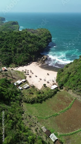 Aerial View of Tropical Beach with Cottages and Vibrant Blue Ocean