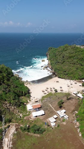 Aerial View of Tropical Beach with Cottages and Vibrant Blue Ocean
