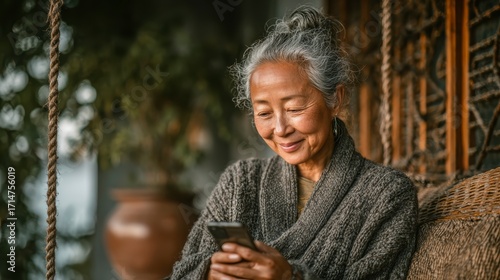 Elderly Woman Smiling While Using Smartphone at Cozy Indoor Setting