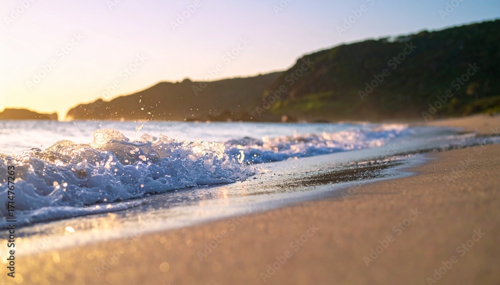 Fototapeta premium Golden hour sunlight washes over a tranquil beach with gentle waves lapping at the shore, creating a serene coastal landscape