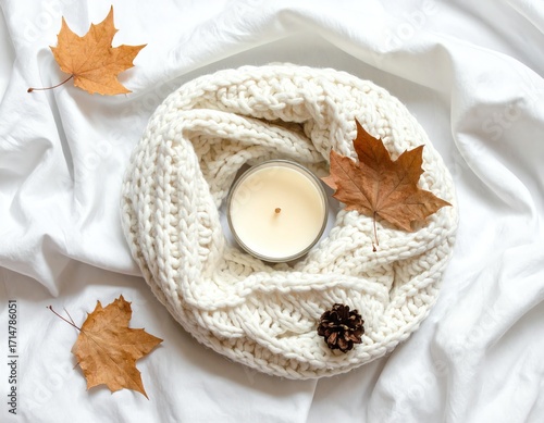 Cozy autumn decor with candle and leaves.