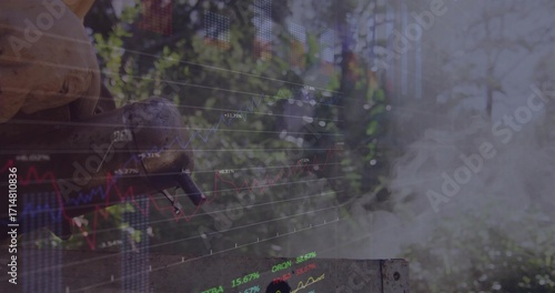 Grasping gloved hand holding tool on backyard grill, with smoke and financial charts, copy space