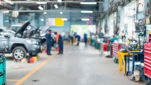 Mechanics work on vehicle repairs in a busy service center with focused tools and equipment