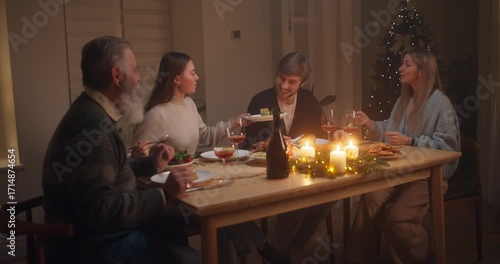 Family gathering around table sharing a meal in cozy home setting with festive decorations