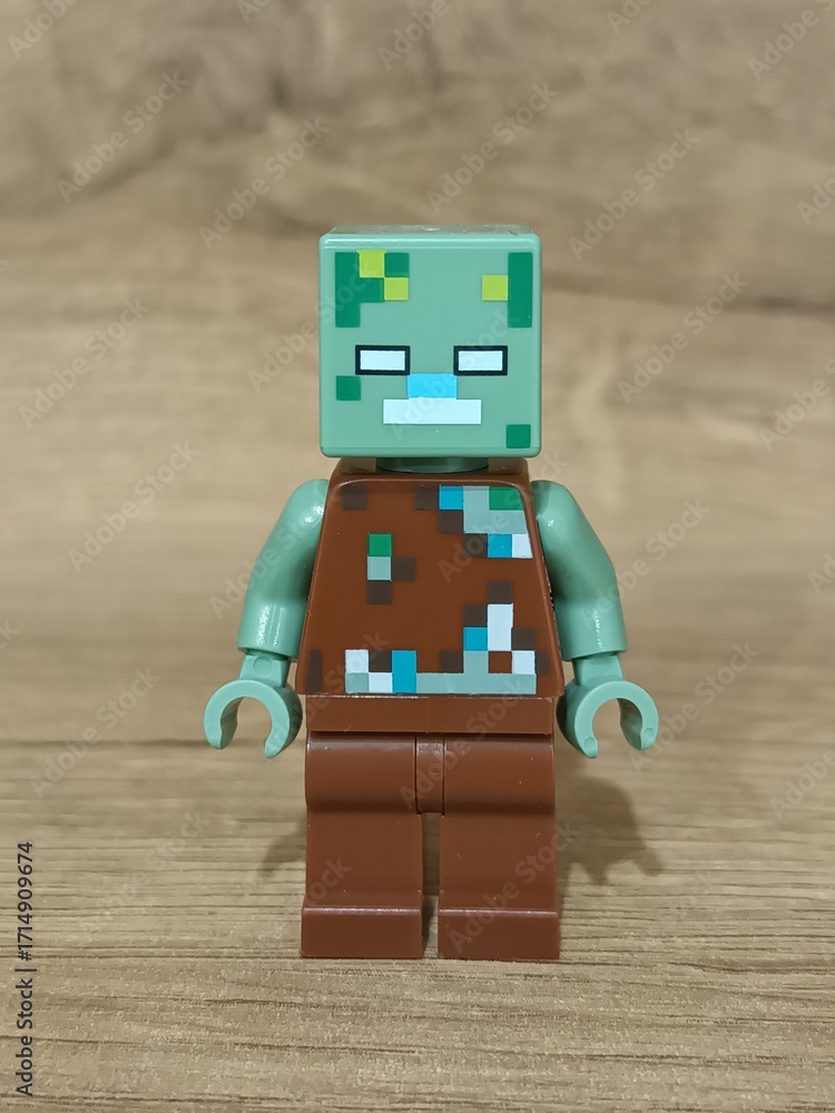 Naklejka premium Whimsical block figures a pink pig-like character with a golden weapon and a grey animal holding a fresh carrot, posed on wood, symbolizing fantasy play and imaginative adventure