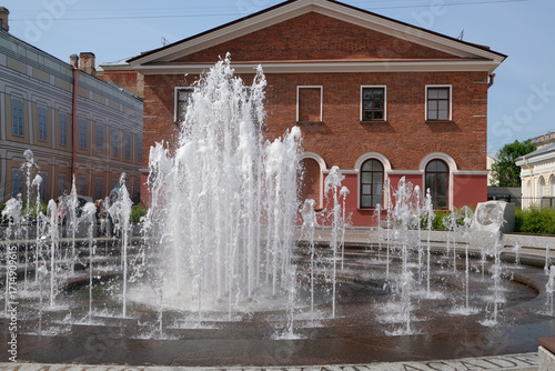 a fountain against the backdrop of a red brick building
