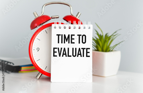 Wallpaper Mural A red alarm clock sits on a table with a white piece of paper that says Time to Evaluate. The clock and paper are arranged in a way that suggests the importance of taking Torontodigital.ca