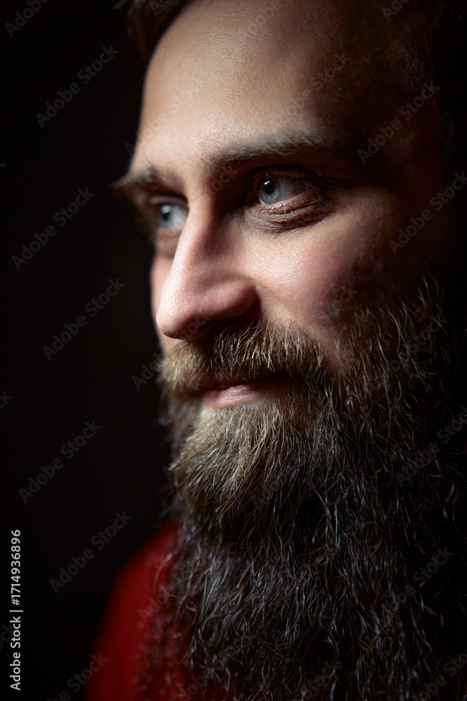 Obraz premium Portrait of a Man with a Beard in Subdued Lighting