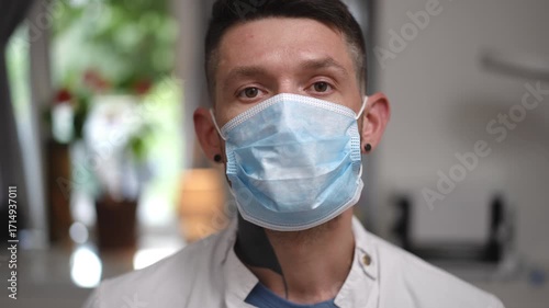 A healthcare worker puts on a mask, highlighting the importance of safety and preparedness in a clinical setting