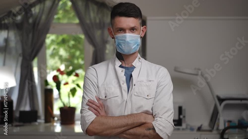A healthcare professional in a mask is ready for patient consultations in a bright, healing environment