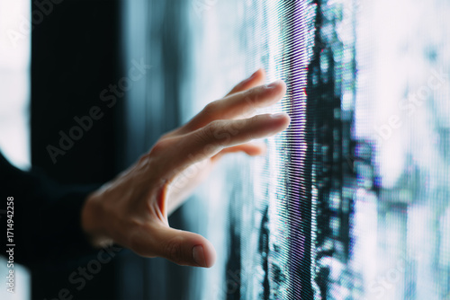 Touching a digital screen displaying vibrant visuals in a modern space