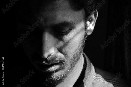 Dramatic Black and White Portrait of a Young Man with Half Face Shadow Lighting
