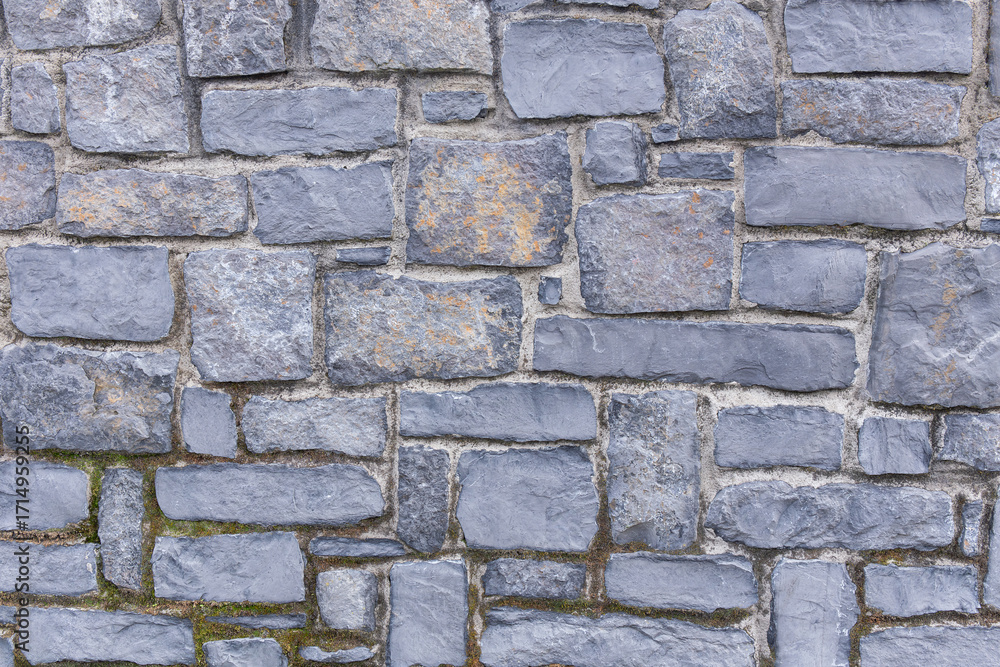 Fototapeta premium Close-Up Of Textured Gray Stone Masonry Wall With Irregular Brick Pattern