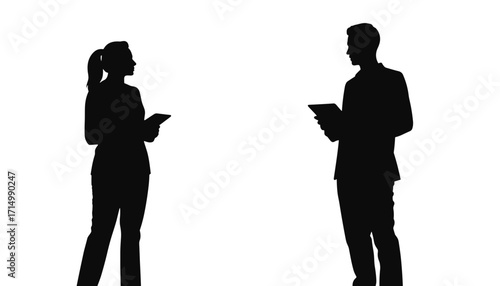 Silhouetted couple holding tablets while engaging in conversation  