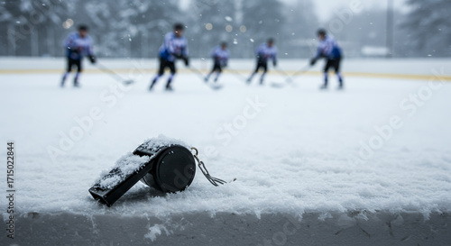 Stopwatch resting on snow while hockey players practice in winter  