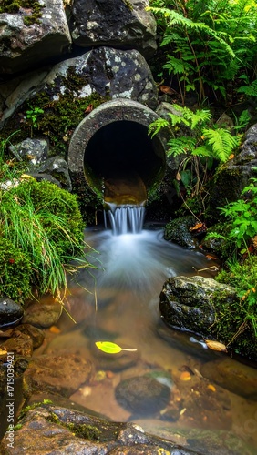 Waterfall Through Stone Drainpipe.
